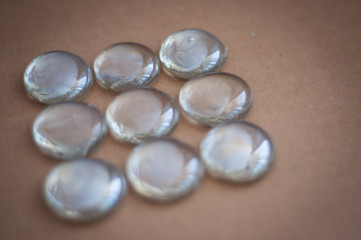 Clear marbles with light reflections on a brown background.
