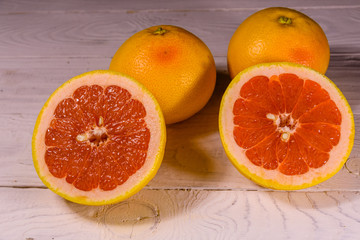 Ripe juicy grapefruit on a white wooden table
