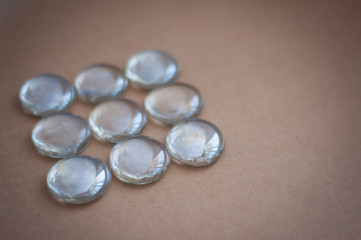 Clear marbles with light reflections on a brown background.