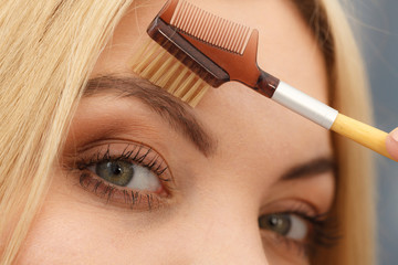 Woman brushing her eyebrows