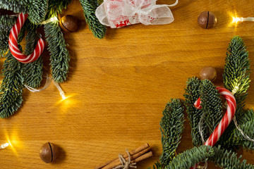 Christmas candys,macadamia nuts and christmas tree branches with a garland in the wooden background