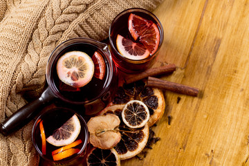 glasses of mulled wine with dry citrus and spices ,knitted sweater.