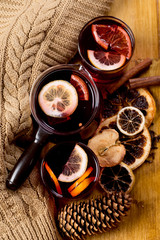 glasses of mulled wine with dry citrus and spices ,knitted sweater.