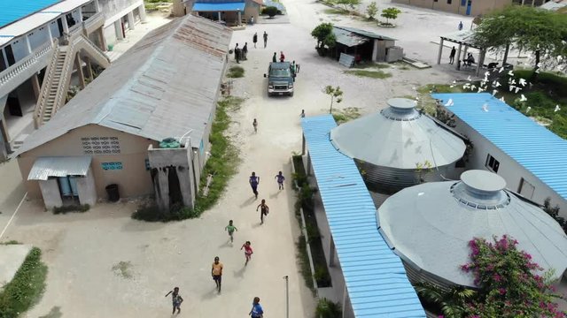 Reverse Aerial Shot Of Island Children Running