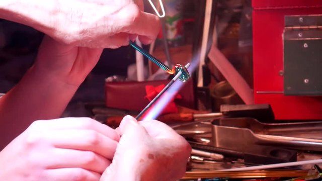 A Student Learning to Melt Glass and Add to Mandrel with a Fire Cut