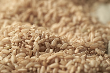 Macro photo of brown rice on a linen tablecloth background. Close up of brown rice.