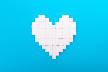 Heart of sugar cubes, blue background