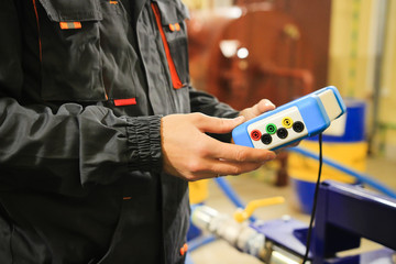 Industrial worker with measuring device on plumbing and boiler course.