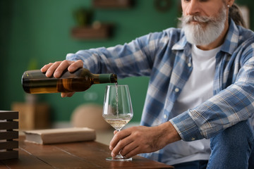 Senior man drinking wine at home