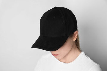 Woman wearing blank cap on light background