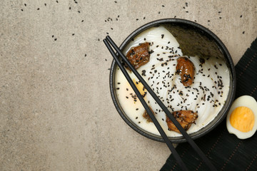 Tasty Chinese soup in bowl on grey table