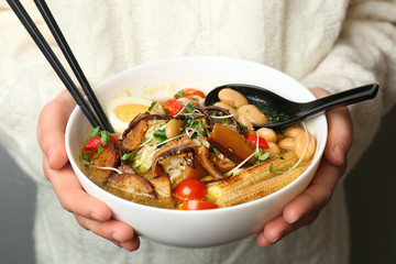 Woman holding tasty Chinese soup, closeup