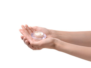 Female hands with jar of cream on white background