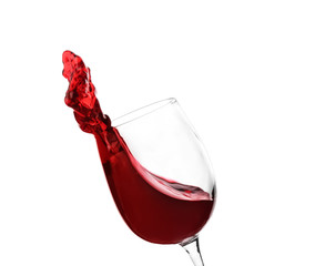 Glass with red splashing wine on white background