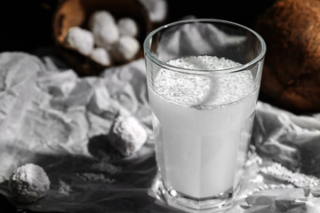 Glass of tasty coconut water on table