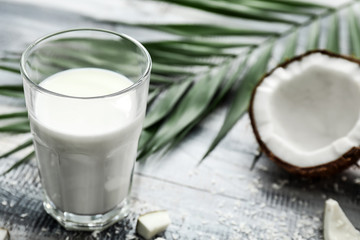 Glass of tasty coconut milk on table
