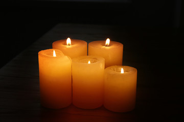 Many burning candles in darkness