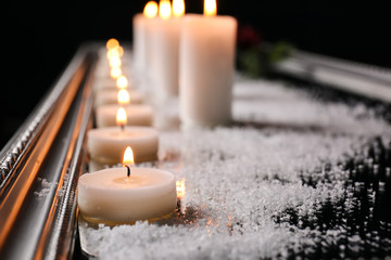 Many burning candles and sea salt on tray