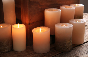 Many burning candles on wooden table