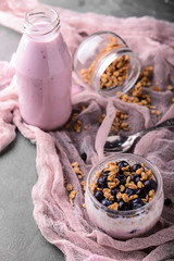 Tasty granola with yogurt on grey table