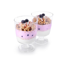 Tasty granola with yogurt in glasses on white background