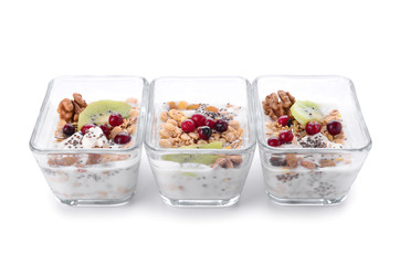 Tasty granola with yogurt in bowls on white background
