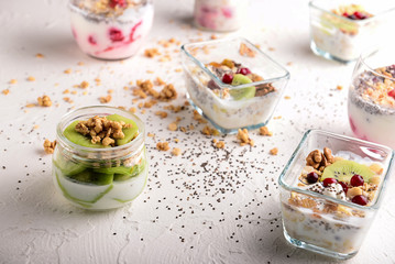 Tasty granola with yogurt and fruits on white table