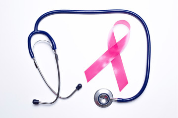 Pink ribbon and stethoscope on a white background. Breast cancer concept. Top view.