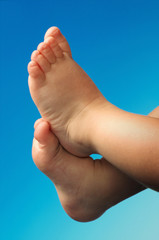 Kleinkind F&uuml;sse vor blauen Hintergrund