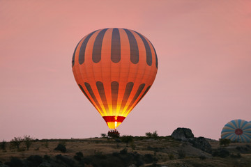 Hot Air Balloon With Fire Light At Morning Valley In Cappadocia