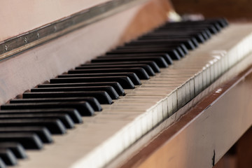 Keys of an old wooden piano. Piano keys on wooden brown musical instrument