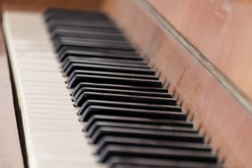 Keys of an old wooden piano. Piano keys on wooden brown musical instrument
