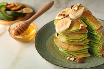 Tasty green pancakes with banana light table
