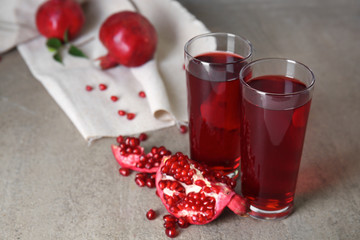 Glasses of tasty pomegranate juice on table