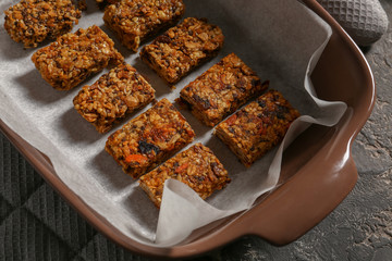 Baking tray with tasty granola bars on table