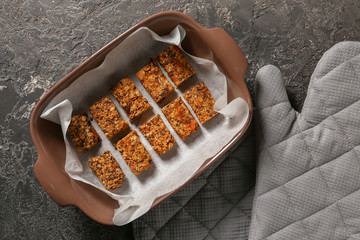 Baking tray with tasty granola bars on table