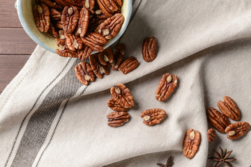 Bowl with pecan nuts on table