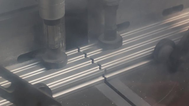 Mitre Saw Cutting Aluminium Extrusion Behind Protective Glass Shield.