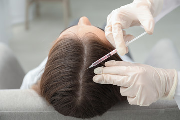 Woman with hair loss problem receiving injection in clinic