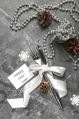 Cutlery with Christmas decor on grey background