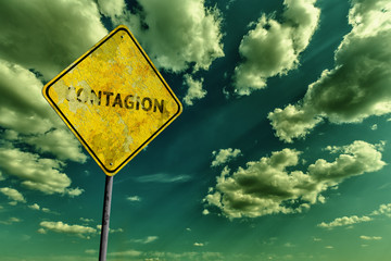 Dark cloudy sky and yellow faded road sign