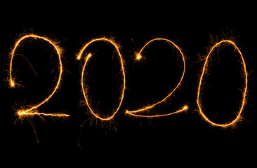 Obraz na płótnie Canvas Jahreszahlen 2020 mit Sternspritzer vor dunklem Hintergrund geschrieben, Symbol für Neues Jahr