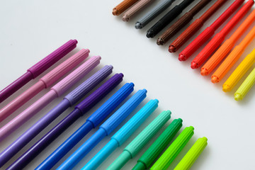 colored pencils, felt-tip pens, markers on a white background, a color palette, a rainbow, office supplies, a range