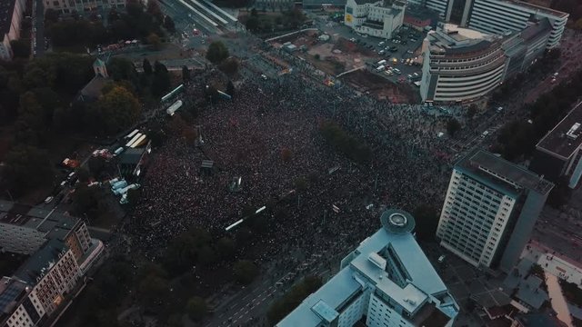 Aerial drone panning above Cheminitz, Germany city as thousands people attend an open air rock concert to stand together against racism with one large stage and people sprawled throughout the streets
