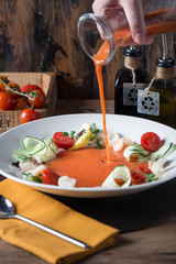Gazpacho gaspacho spanish traditional vegetable tomato soup in glass bowl with vegetables on old wooden table. Served by chef