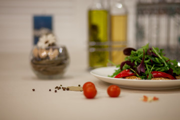 Meat, fish, salads on the table in white plate in the interior with olive oil