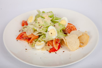 Meat, fish, salads on the table in white plate in the interior with olive oil