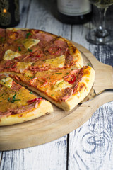 Hawaiian pizza with pineapple on old wooden table, rustic still life style.
