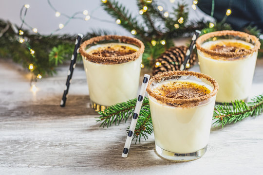 Homemade eggnog in glasses on wooden table surface