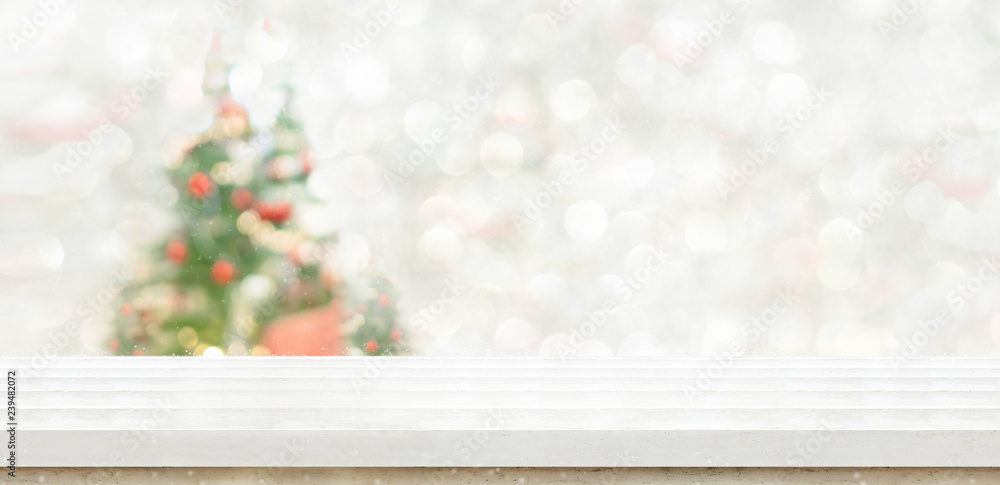 Leinwandbilder White marble table top at blur bokeh christmas tree decor with string light background when show falling,Winter holiday greeting card